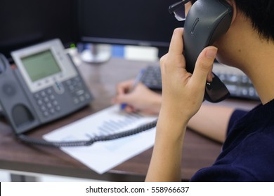 close up call centre man working and talking via telephone in office room concept.