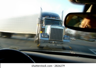 Close Call Imminent Crash Accident With A Tractor Trailer Truck Viewed From Inside A Passenger Car With Scared Driver Face In Rear View Mirror