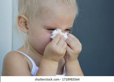 Close Up Candid Portrait Of Toddler Girl Blowing Nose. Runny Nose Caused By Cold, Flu Or Allergy.