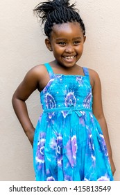 Close Up Candid Snapshot Of Laughing African Girl In Front Of Wall Outdoors.