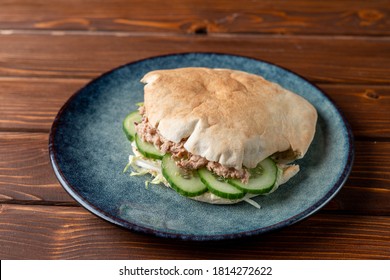 Close Up Of Canned Tuna Pita With Cucumber, Tuna Sandwich On A Wooden Table And Blue Clay Plate