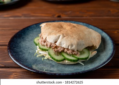 Close Up Of Canned Tuna Pita With Cucumber, Tuna Sandwich On A Wooden Table And Blue Clay Plate