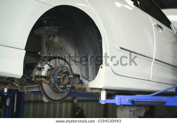 Close up of car brake repairing in garage ,disc\
brake of the vehicle for\
repair.