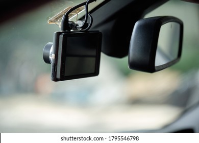 Close up of car camera mount on windshield. Car camcorder is onboard camera that records the view through a vehicle's front windscreen. Dashcams can provide video evidence in event of a road accident.