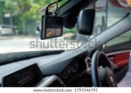 Close up of car camera mount on windshield. Car camcorder is onboard camera that records the view through a vehicle's front windscreen. Dashcams can provide video evidence in event of a road accident.