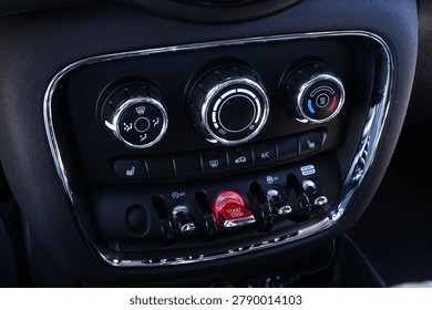 Close up car climate control panel. Premium dashboard climate panel with chrome rings rotary dials for fan temperature and air flow plus illuminated red start engine stop button. It highlights advanced vehicle interior controls modern functionality stylish automotive engineering excellence. 