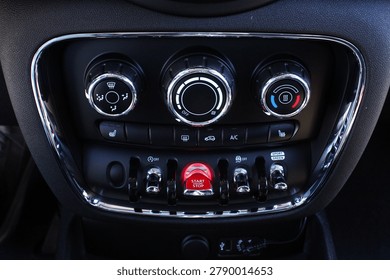 Close up car climate control panel. Premium dashboard climate panel with chrome rings rotary dials for fan temperature and air flow plus illuminated red start engine stop button. It highlights advanced vehicle interior controls modern functionality stylish automotive engineering excellence. 