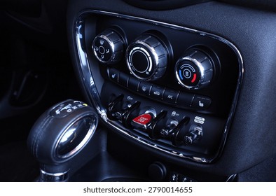Close up car climate control panel. Premium dashboard climate panel with chrome rings rotary dials for fan temperature and air flow plus illuminated red start engine stop button. It highlights advanced vehicle interior controls modern functionality stylish automotive engineering excellence. 