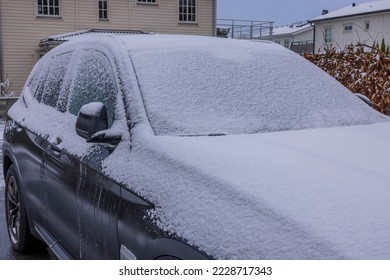 Close up of car covered in snow in private parking lot on winter day. Sweden.