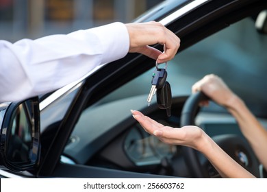 Close up of car dealer giving keys of a new car to woman. Concept for car rental  - Shutterstock ID 256603762