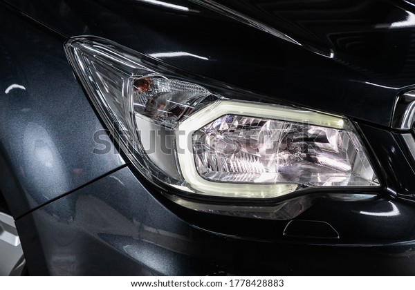 Close up of the car detailing: beauty clean\
headlights of black SUV\
