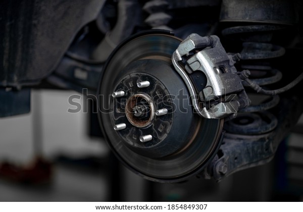 Close up of car disc brake during the wheel tire\
change or repair. Disc brake of the car during the maintenance at\
auto service garage.