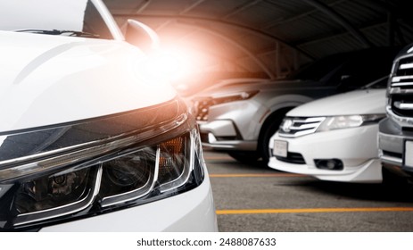 Close up of car headlight on parking lot. with blurred of other cars in parking lot under roof for background. - Powered by Shutterstock