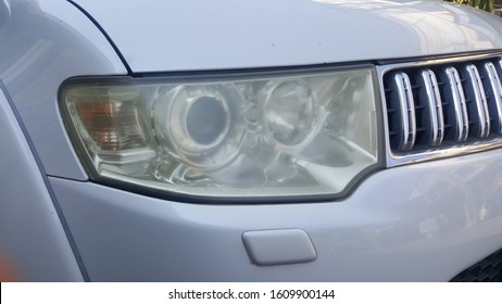 Close Up  Car Headlight. Unpolished Cloudy Foggy Front Headlight Of Ollose Up Dirty Car Headlight. Unpolished Cloudy Foggy Front Headlight Of Old Car. Car Headligh Cleaning Concept.