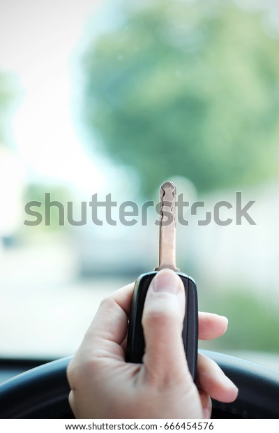 Close up of Car key with remote control\
in hand, selective focus and vignette\
effect.