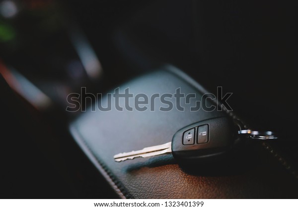 Close up of a car\
key ring and remote control alarm system charm in vehicle new car\
interior. soft focus. 
