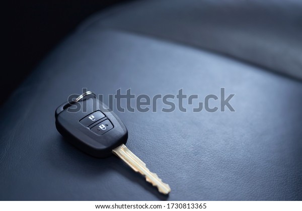 Close up of a car key ring\
and remote control alarm system charm in  new vehicle interior. or\
Forget placed on the seat inside. concept transport travel. soft\
focus.