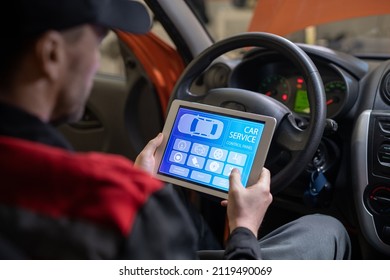 Close up of car mechanic using digital tablet with service and maintenance app on screen while inspecting vehicle in auto repair shop - Powered by Shutterstock