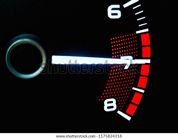 close up of car\
meter with black\
background