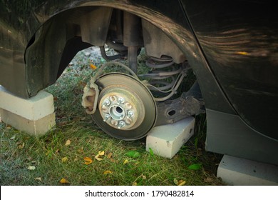 Close Up Of Car On Bricks Outside. Concept Of Stolen Vehicle Wheels. Car With Missing Wheel.