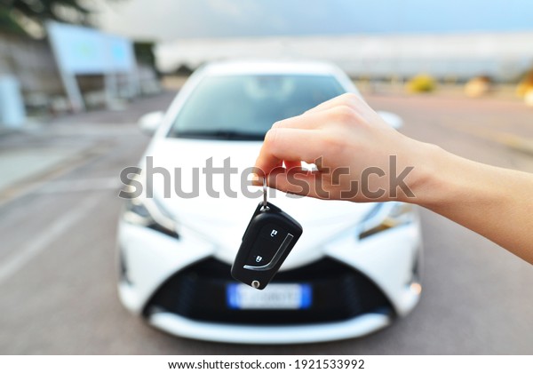 Close up of the car\
owner\'s hand holding the delivery key to buyers. Concept of selling\
cars and giving keys to new owners. Car salesmen and keys\
presenting car trading.