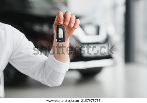 Close up of the car owner's hand holding the
delivery key to buyers. Concept of selling cars and giving keys to
new owners.