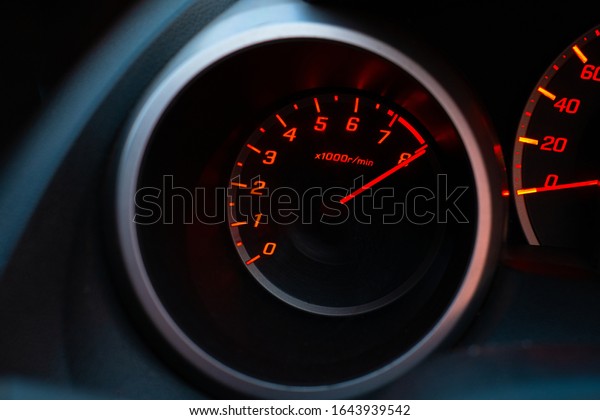 Close up of car speedometer with the needle\
pointing at 8 krpm on black\
blackground