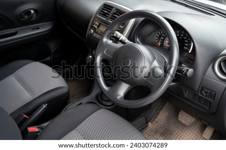 Close up Car steering wheel inside the used car cabin.Dark colored Interior of modern car. steering wheel in the used modern motor wheel.