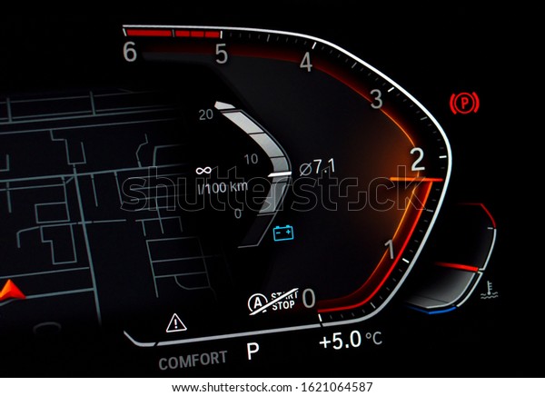 Close up of car tachometer displaying almost 2000\
RPM. Modern fully digital vehicle dashboard with average fuel\
consumption and temperature gauge. Luxury business car cluster with\
rev counter at night