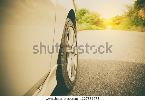 Close up car tire with road way to adventure to\
the country