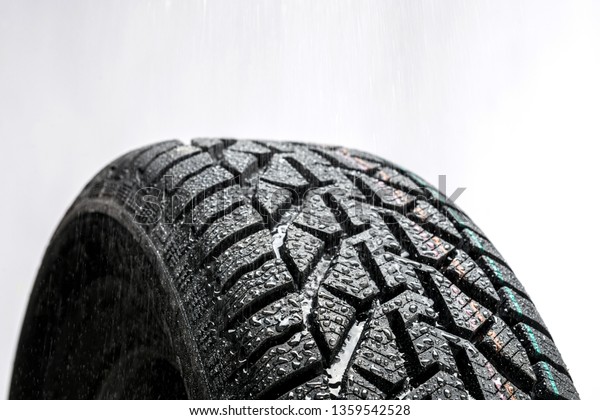 Close up of car tire  with water droplets\
isolated on white\
background