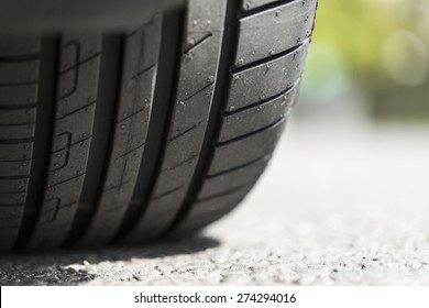 Close up of car tyre tread on the road on a bright day