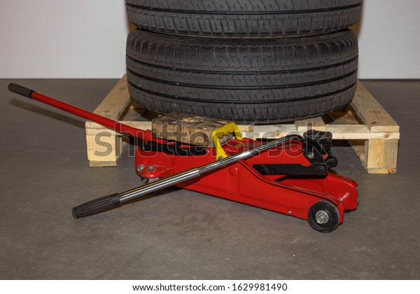 Close up car\
tyres on wheels storage  on a pallet and tire replacement jack. Car\
repair box. Transport\
backgrounds.