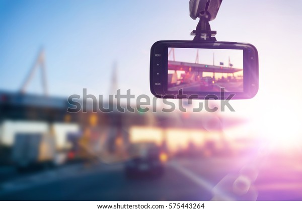 Close up car video recorder driving a car on\
highway at sunset