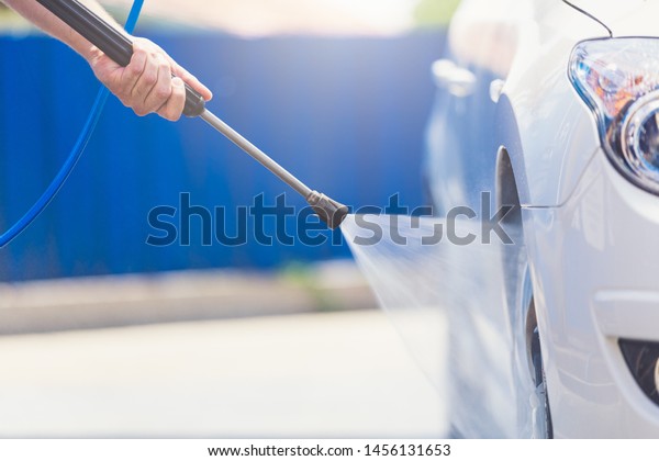 Close up car washing with high pressure car washer\
spray gun