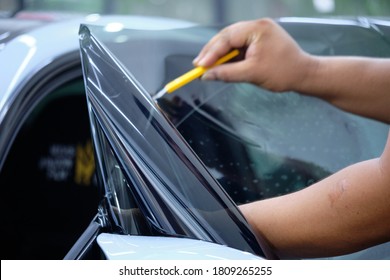 Close up of car window tint installation. Ceramic film provide heat rejection & UV protection. Automotive film installed to car glass surface. Professional tinting service background. Hand moving - Shutterstock ID 1809265255