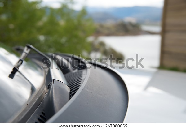 Close\
up of car windscreen wipers parked next to a\
lake