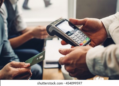 Close Up Of A Card Payment Being Made Betweem A Man And A Waiter In A Cafe.