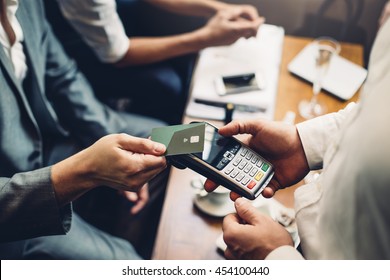 Close up of a card payment being made betweem a man and a waiter in a cafe.