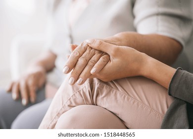 Close up of caregiver holding woman's hand