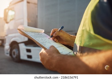 Close up of cargo dispatcher writing on clipboard on truck parking lot. - Shutterstock ID 2186156791