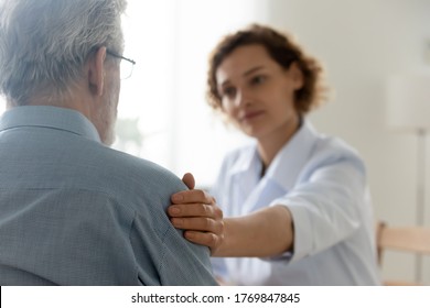 Close Up Of Caring Young Caucasian Female Nurse Or Caregiver Touch Support Senior Male Patient, Attentive Woman Doctor Or GP Feel Supportive Comfort Upset Mature Man Client, Elderly Healthcare Concept