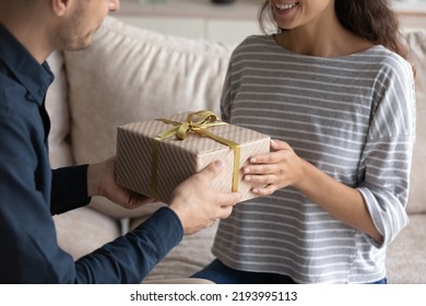 Close Up Caring Young Man Giving Wrapped Carboard Box To Wife, Congratulating With Happy Birthday Or Special Event. Loving Sincere Millennial Generation Family Couple Celebrating Wedding Anniversary