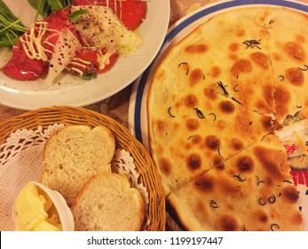 Close Up Carpaccio Di Manzo Con Salsa Cipriani(Sliced Beef With Sauce) Served With Plain Pizza Base And Butter Garlic Bread