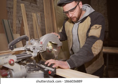 Close up a carpenter in work clothes doing woodwork in carpentry. small buiness owner cut on wood plank with circular saw in workshop