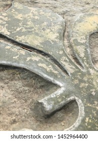 Close Up Carved Stone Fleur Di Lis On Gray Stone Garden Bench