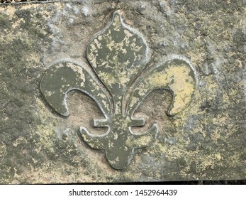 Close Up Carved Stone Fleur Di Lis On Gray Stone Garden Bench