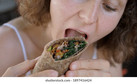 Close Up Of A Caucasian Girl Eating Healthy Delicious Vegan Wrap With Massive Pleasure. .