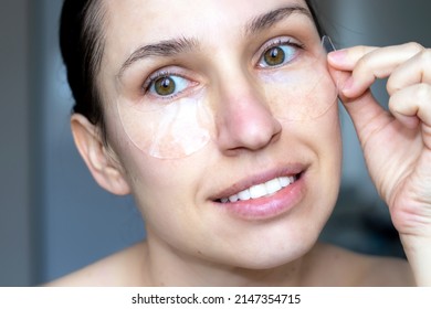 Close Up Of Caucasian Girl, Woman With Natural No Makeup Look And White Teeth Smile, Take Off Or Has Silicone Eye Patches. Smiling, Excited, Happy Woman, Home Skincare, Dark Circles. Looks Up