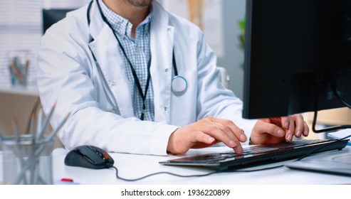 Close Up Of Caucasian Male Professional Doctor Specialist Typing On Computer Keyboard Browsing Online At Work While Sitting In Clinic Office At Workplace, General Practitioner Tapping On Computer